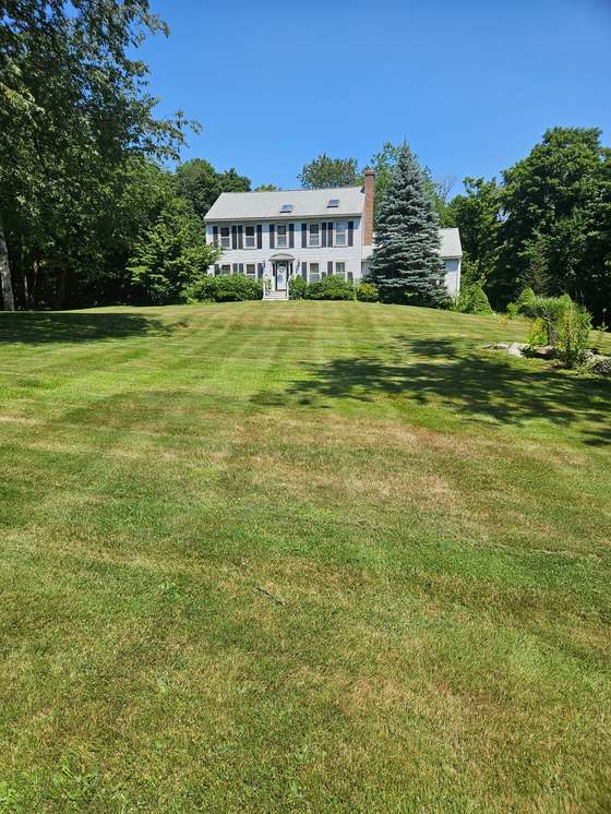 Wide mowed front lawn at a white colonial home
